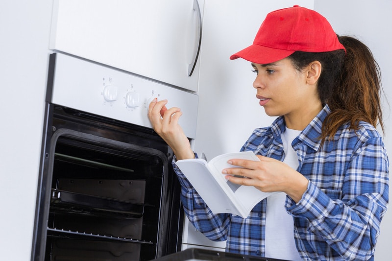 Portrait female checking oven