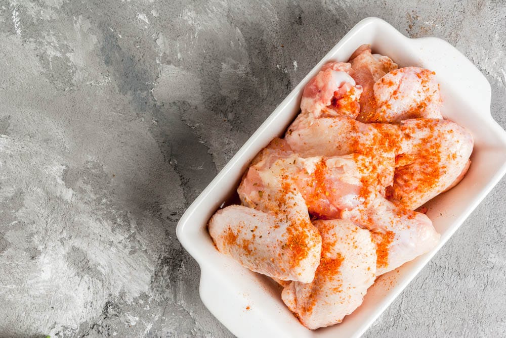 Fresh raw chicken wings in a baking dish