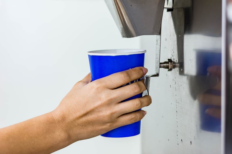 Hand of woman serving ice of ice maker machine