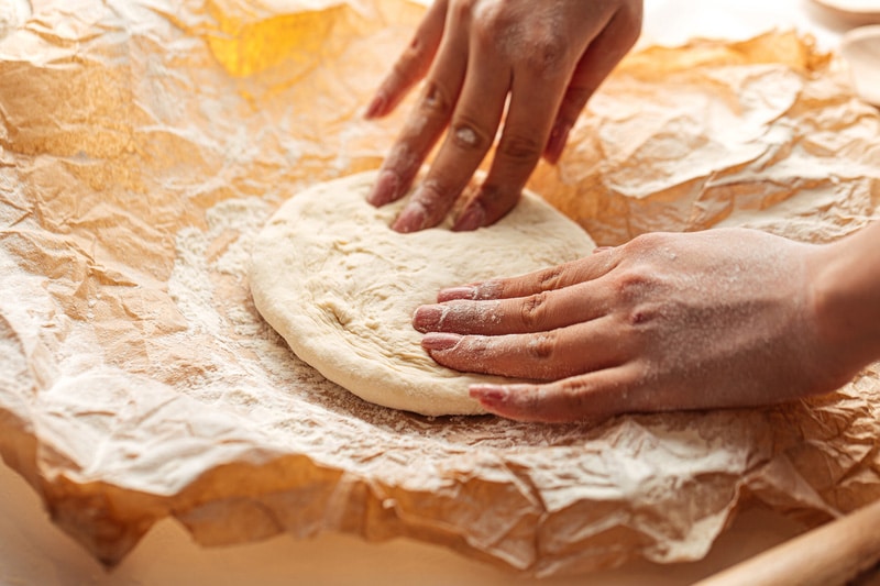 Kneading dough for pizza cooking on the paper