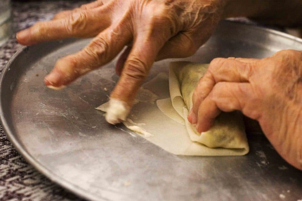 Old hand making lumpia