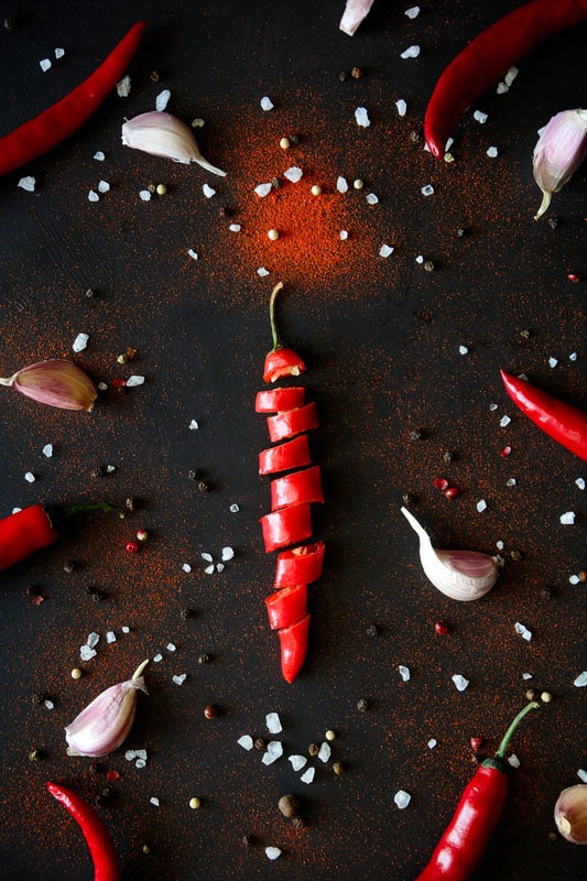 Sliced ripe red chili pepper, garlic, pods, peas and powder
