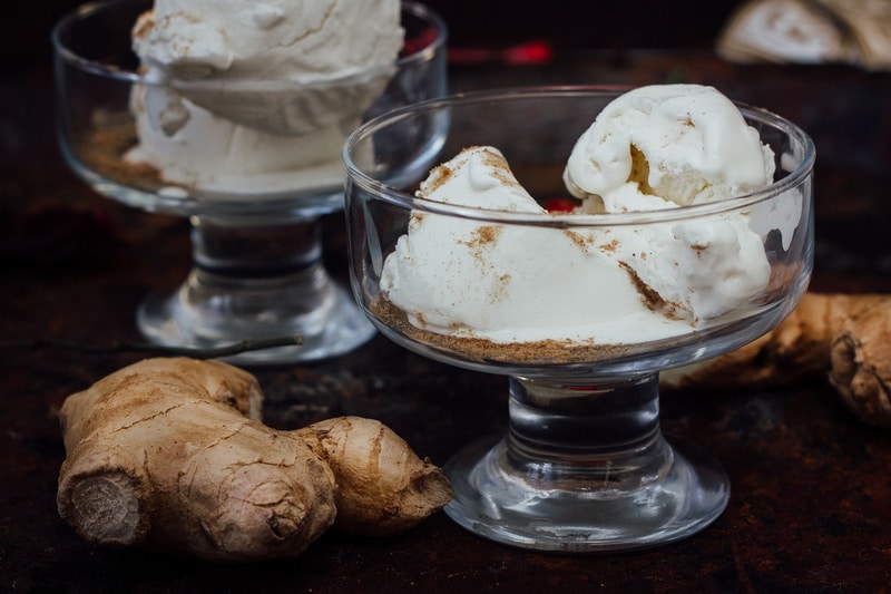 White ginger ice cream on transparent glass on black surface