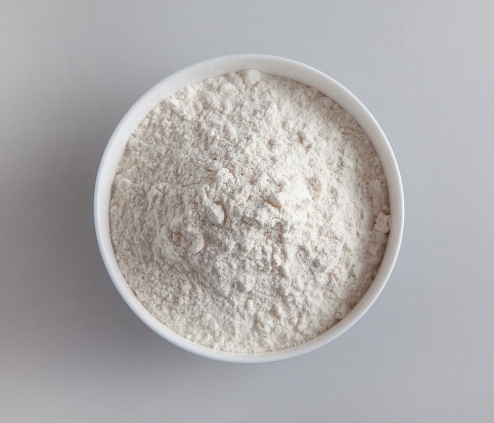 Bowl of flour on grey kitchen table background