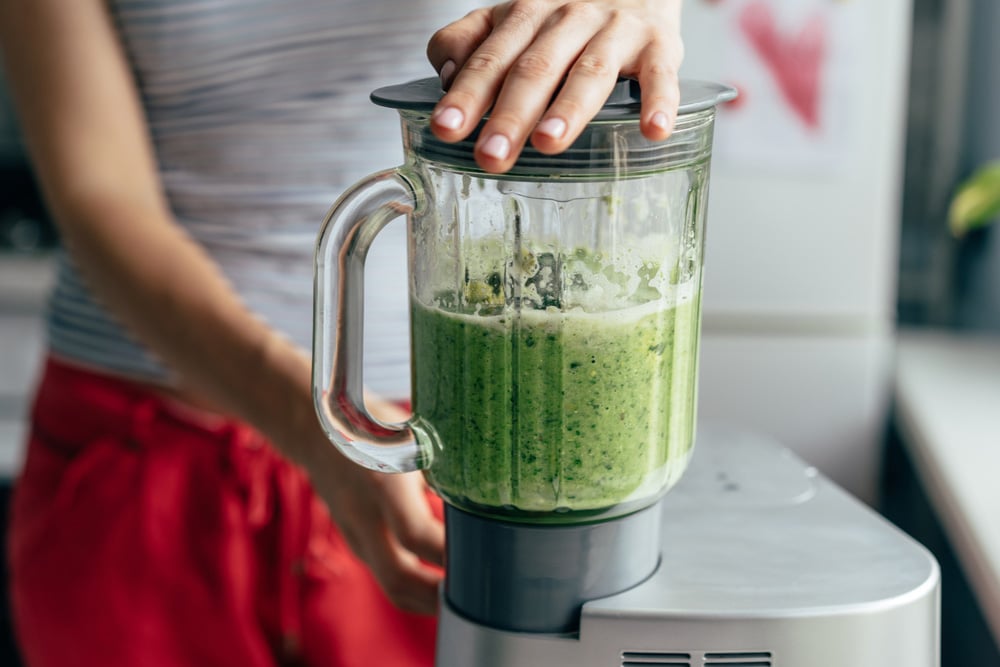 Close-up blender process cooking a green spring smoothie