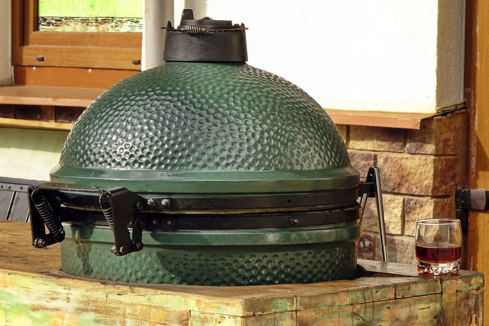 Closeup of green ceramic BBQ grill mounted in the table 