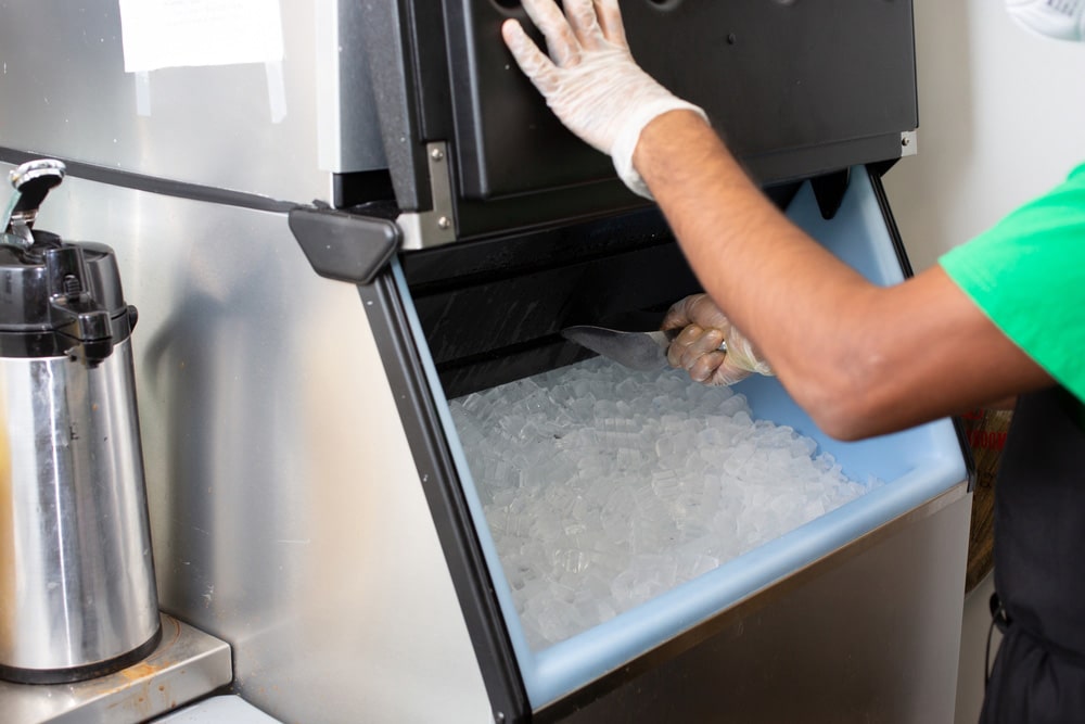 A view of an employee scooping ice out of an ice machine