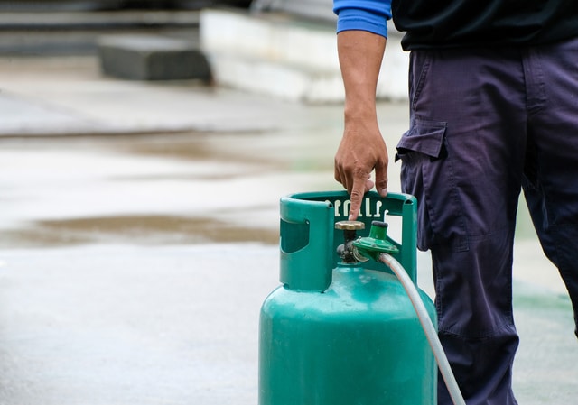 Man's hand pointing to LPG gas open valve