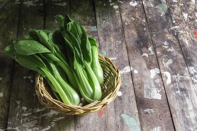 Bok choy vegetable in basket on wood background