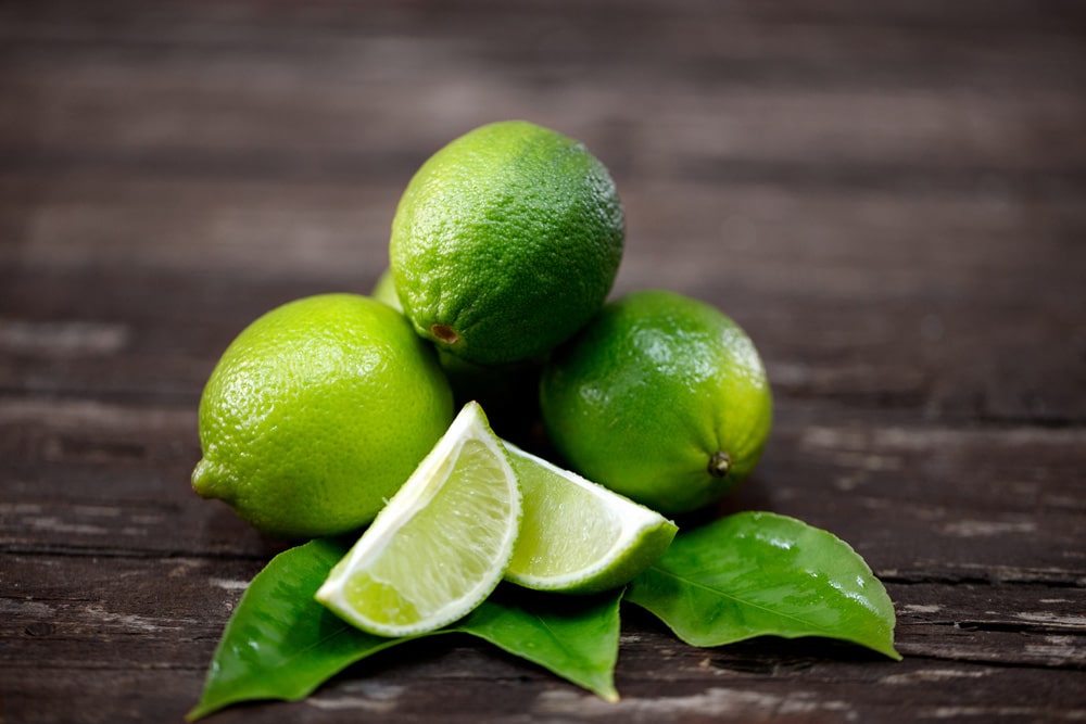 Lime juice with lime slices on wooden table
