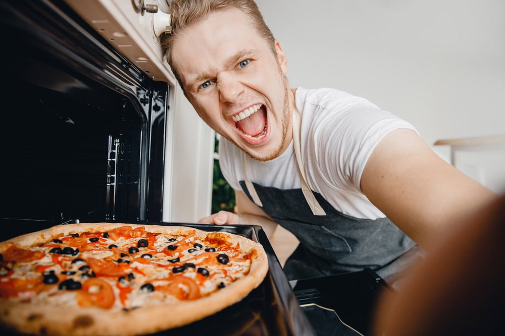 Man chef makes selfie photo with hot pizza from oven