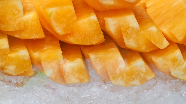 Orange or yellow pineapple sliced on crushed ice