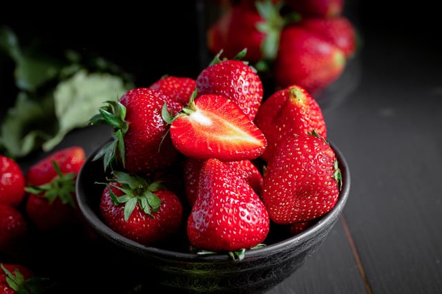 Ripe red strawberries on dark wooden background