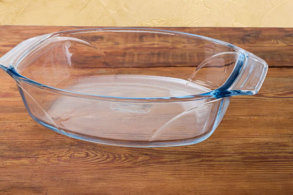 Empty oval glass casserole pan on an old rustic table