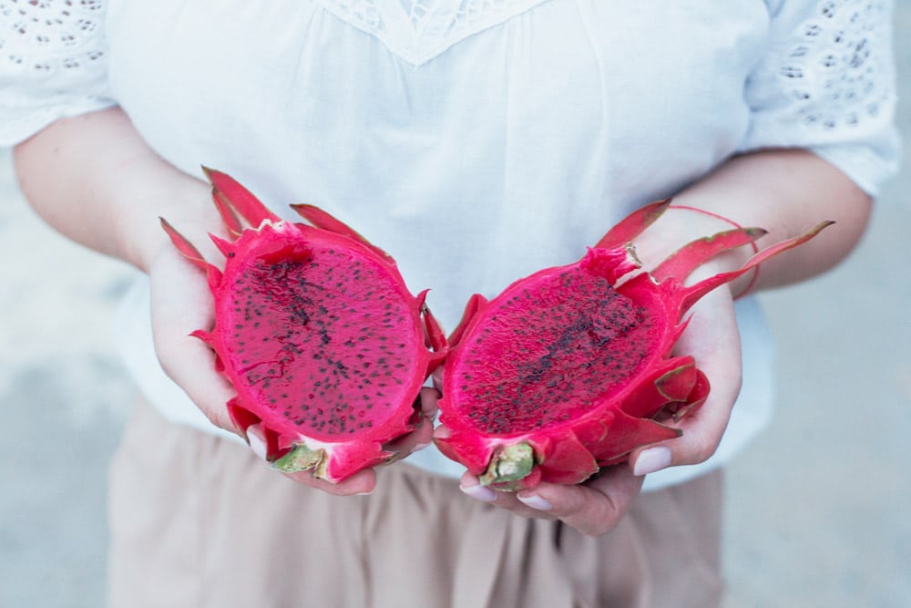 Girl holds a bright dragon fruit