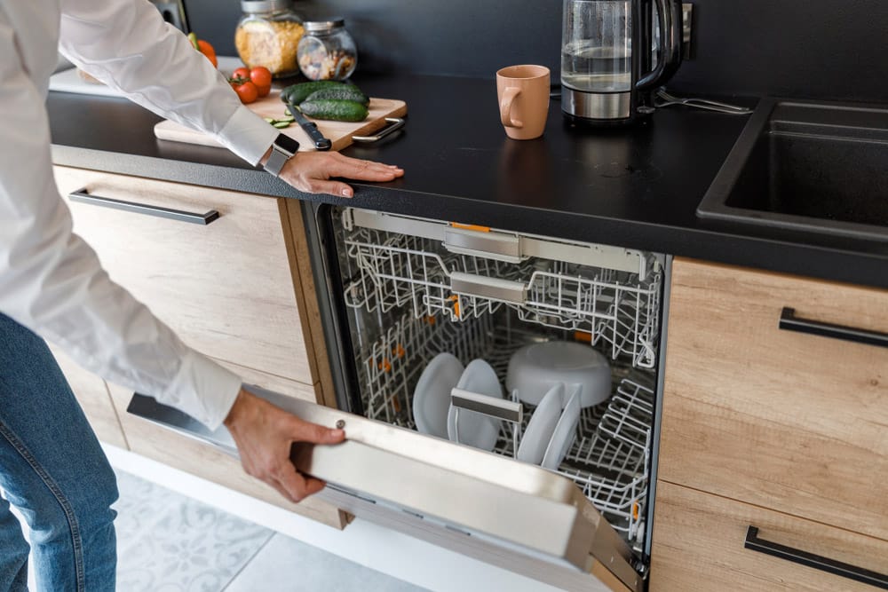 Lady opening the door of the dishwasher