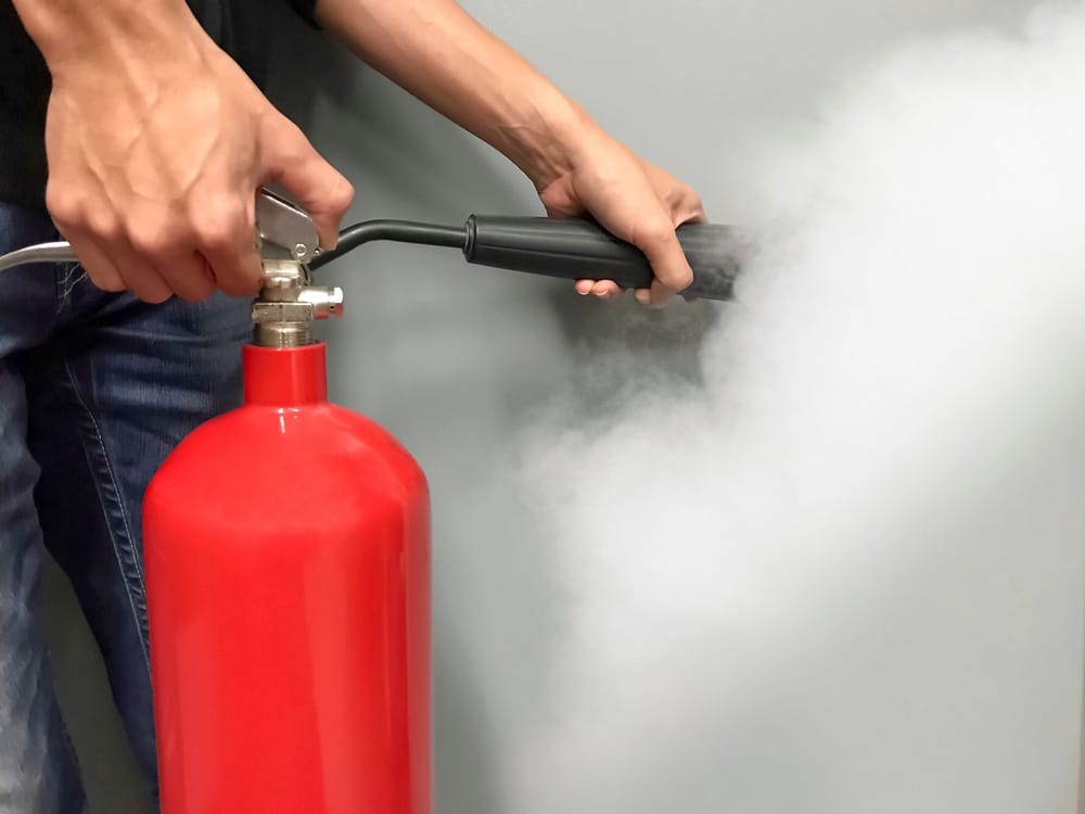 Men hands using red fire extinguisher