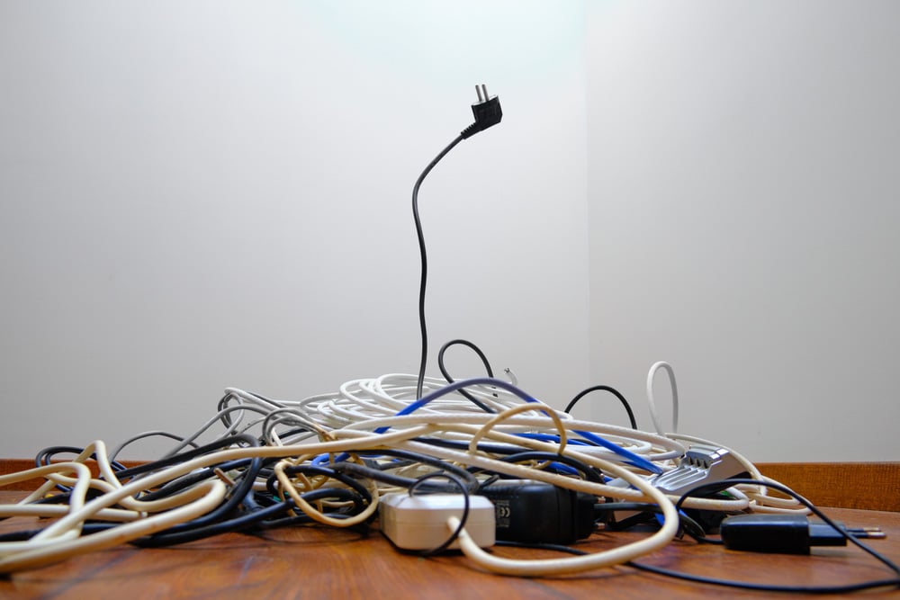 A tangled tangle of unnecessary wires lies on the floor