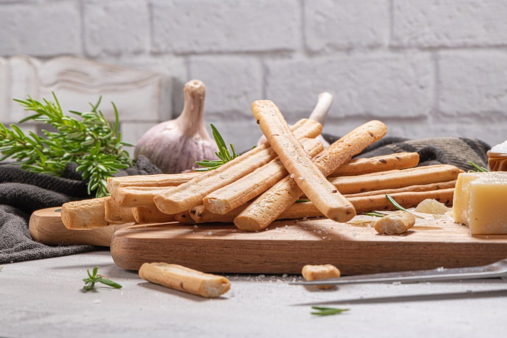Traditional Italian breadsticks grissini with rosemary, parmesan cheese, olive oil, garlic and salt
