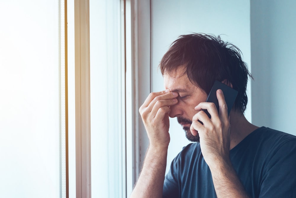 Worried anxious man talking with someone on mobile phone