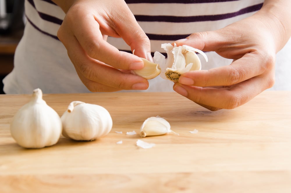 Woman peeling garlic by hand for cooking