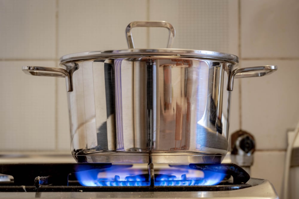 Stainless steel pressure cooker on hob