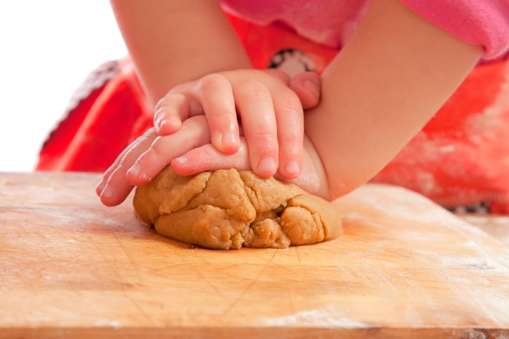 Little girl kneading a gingerbread dough
