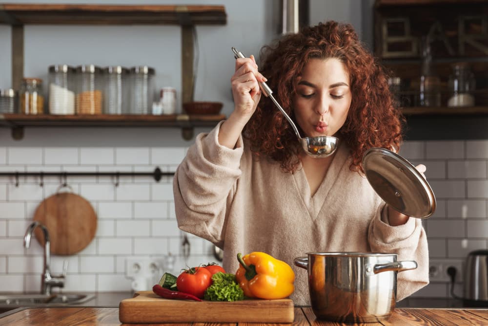 Photo of pretty caucasian woman holding cooking ladle spoon while eating soup