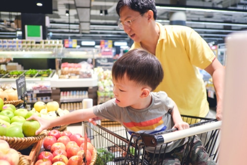 Asian father and son are shopping fruits in supermarket