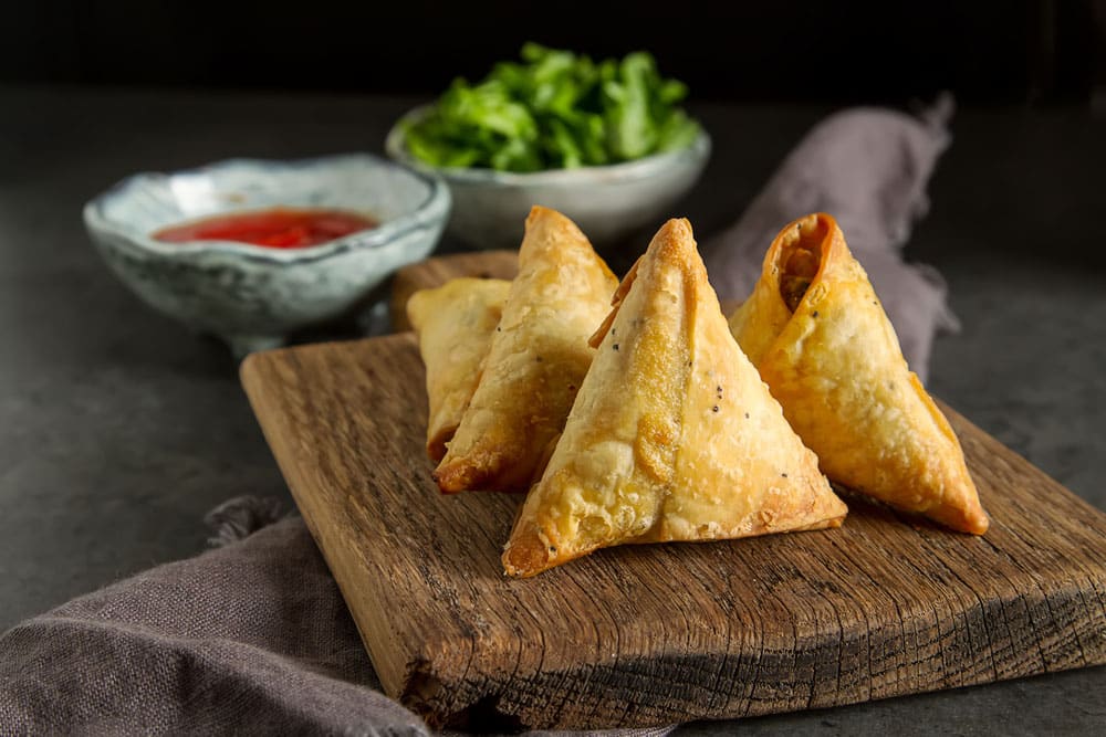 Vegetarian samosa with tomato sauce and herbs