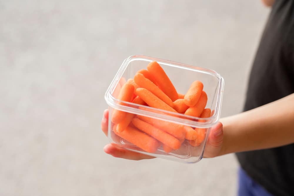 Baby carrots snack container in kid's hand