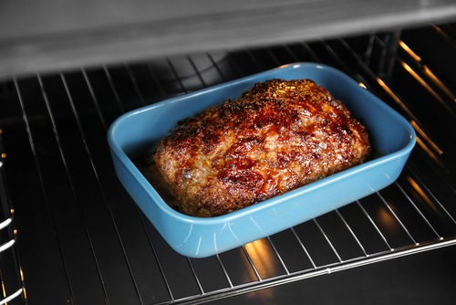 Baking dish with delicious turkey meatloaf in oven