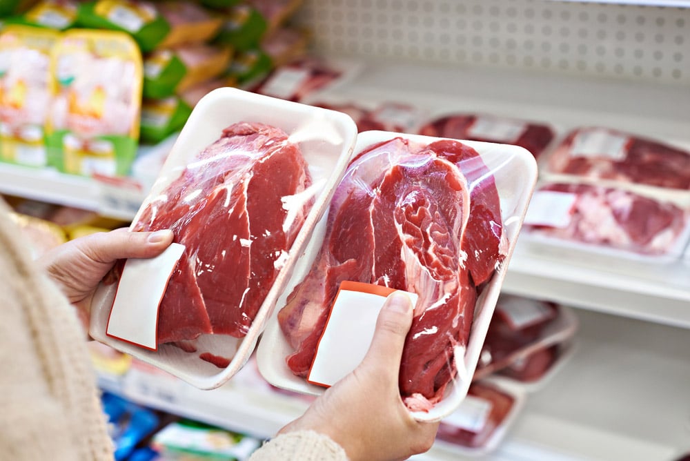 Buyer hands with beef meat packages at the grocery store