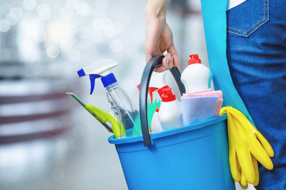 Cleaning lady holding a bucket of cleaning products in her hands