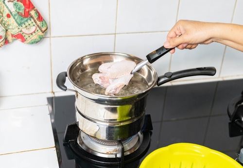 Cooker use ladle scoop chicken middle wings pouring to boil water pot for cooking