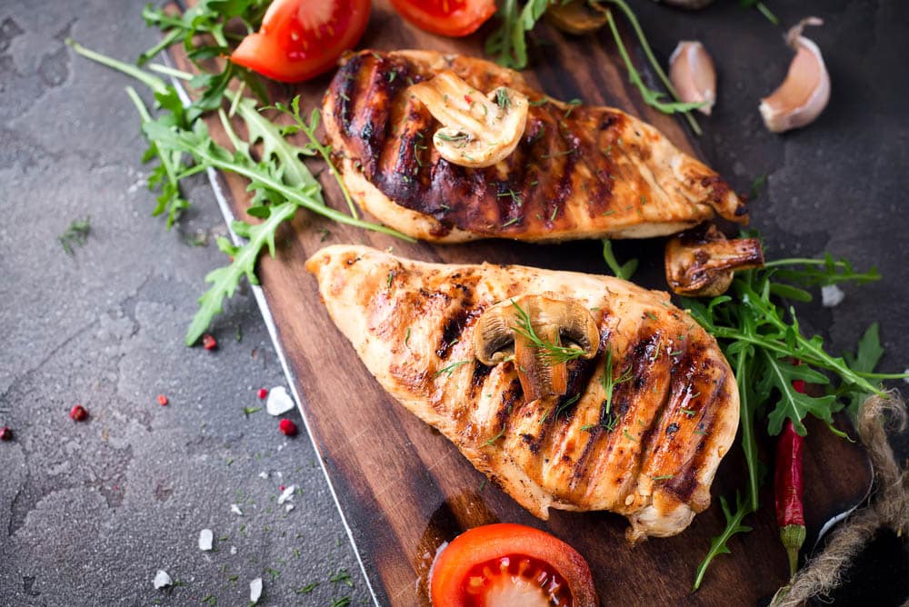 Healthy food - grilled chicken with vegetables on a wooden board