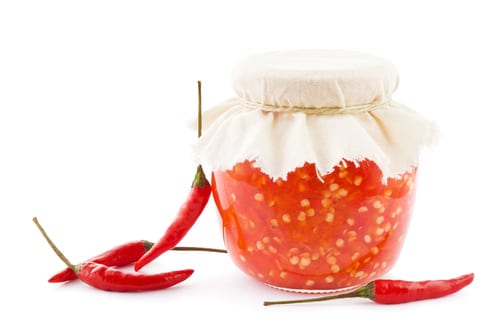 Jar with homemade sambal oelek and fresh chili peppers