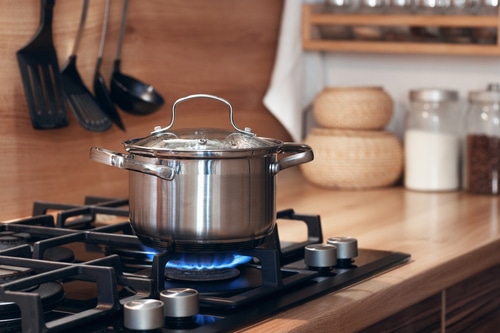 Stainless pan on the hob cooking on a gas stove