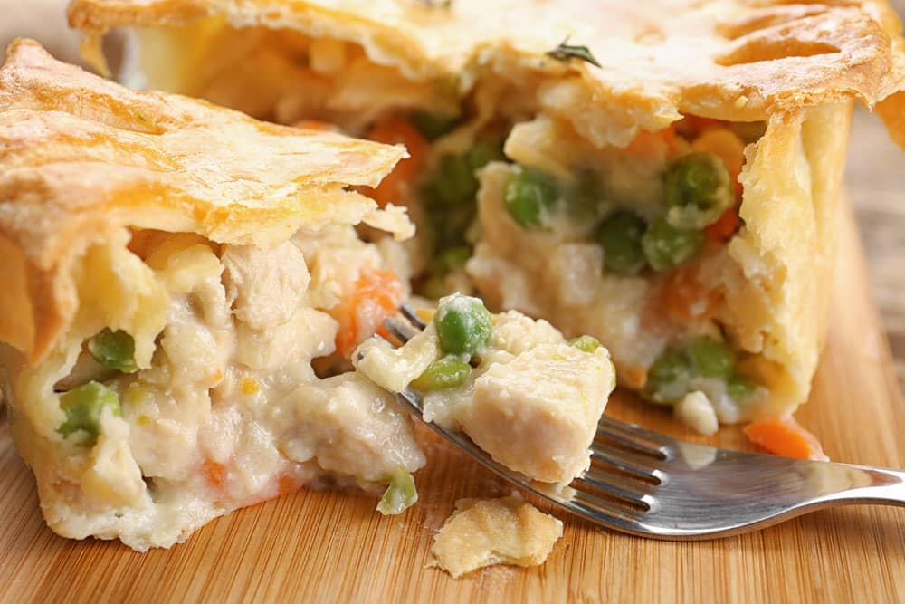 Tasty baked chicken pot pie on wooden board