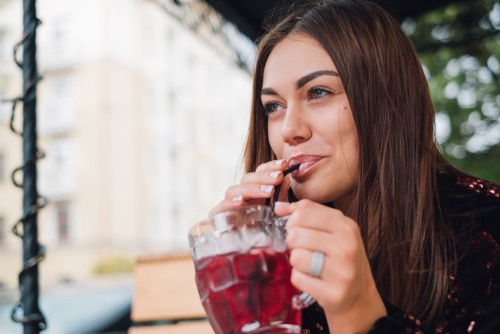 Woman drinking from a drinking straw fresh summer drink