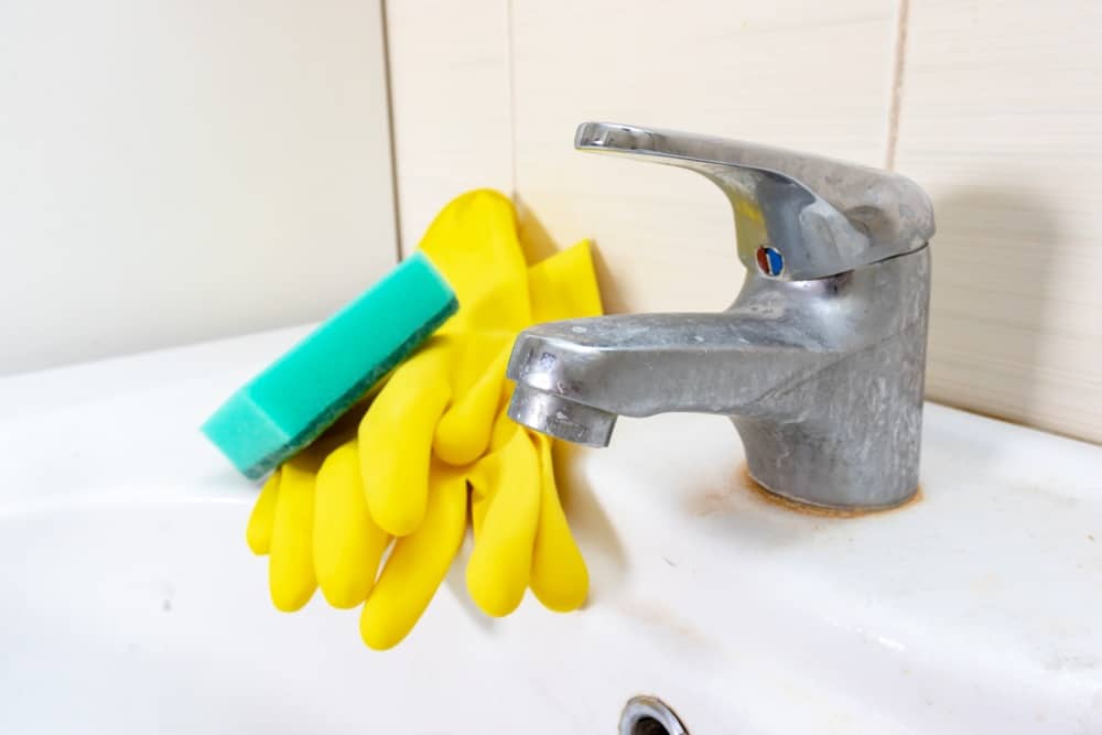 Sponge and gloves for washing dirty faucet with limescale hard water