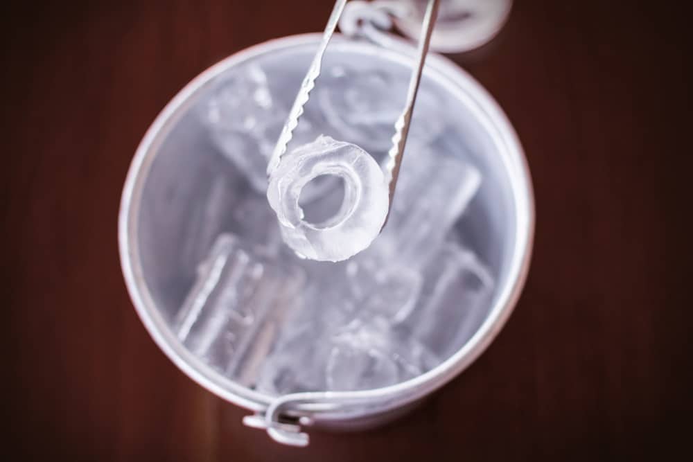 ice taken out from silver bucket using tongs