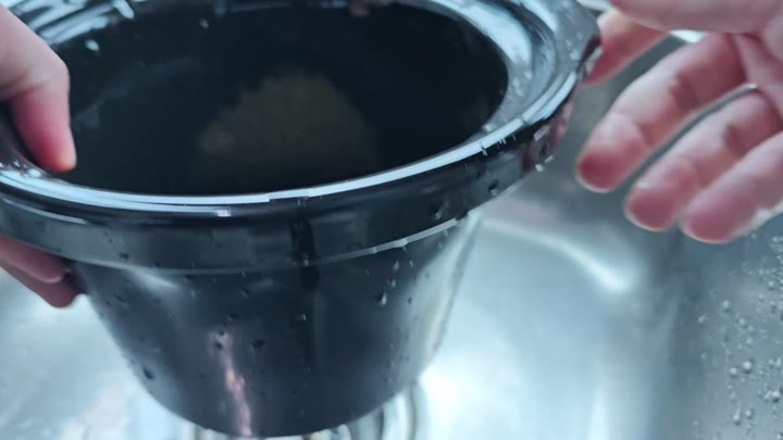 Draining water from rice container Draining water from rice container