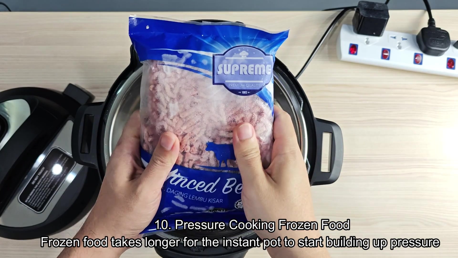 Frozen minced beef bag above open cooker Frozen minced beef bag above open cooker