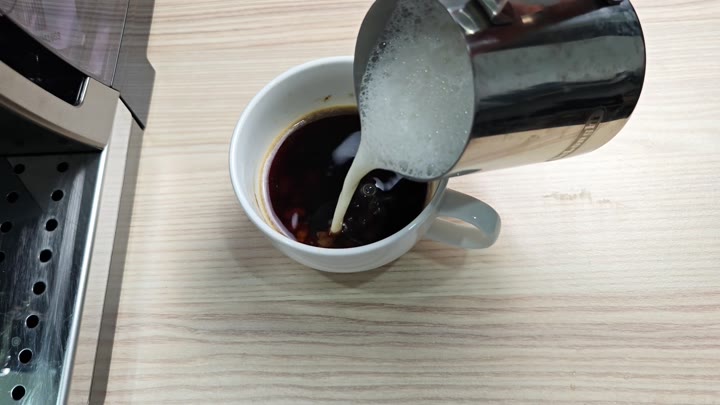 Pouring frothed milk into coffee for a cappuccino Pouring frothed milk into coffee for a cappuccino