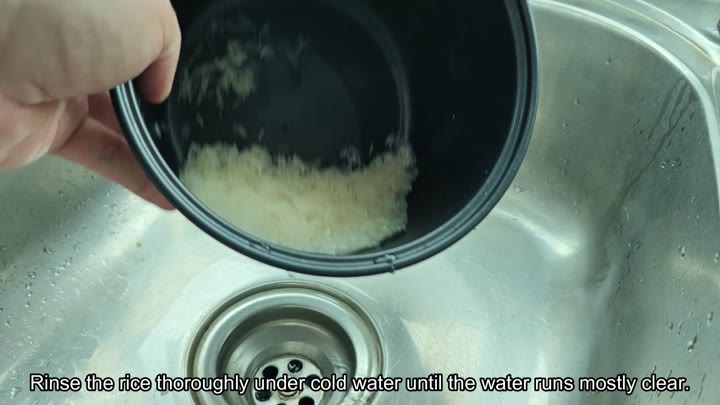 Rinsing jasmine rice under cold water Rinsing jasmine rice under cold water
