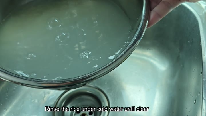 Rinsing rice under cold water Rinsing rice under cold water