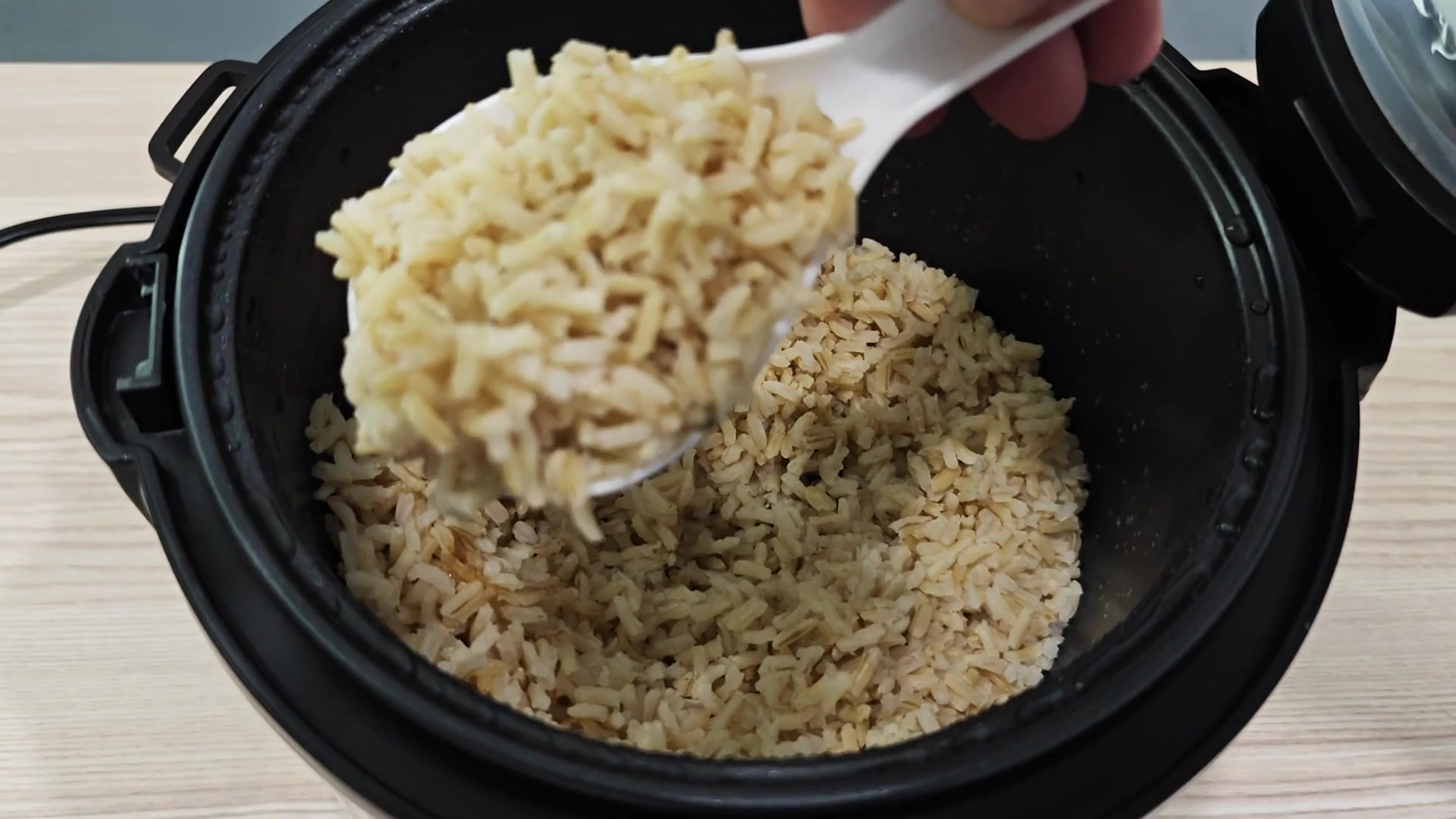 Scooping a portion of cooked brown rice Scooping a portion of cooked brown rice