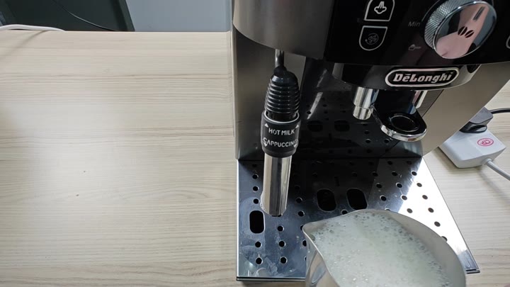 Steam wand frothing milk in pitcher Steam wand frothing milk in pitcher