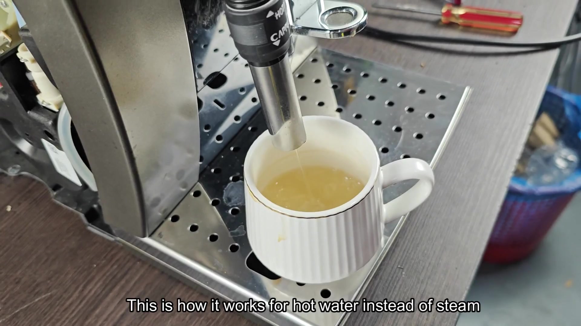 Wand dispensing liquid into white cup Wand dispensing liquid into white cup